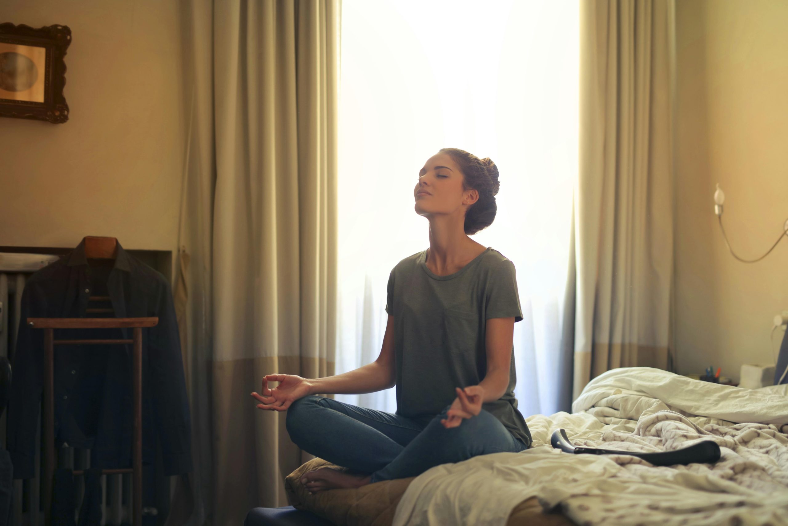 Person meditating as a mindfulness practice to manage stress and anxiety.